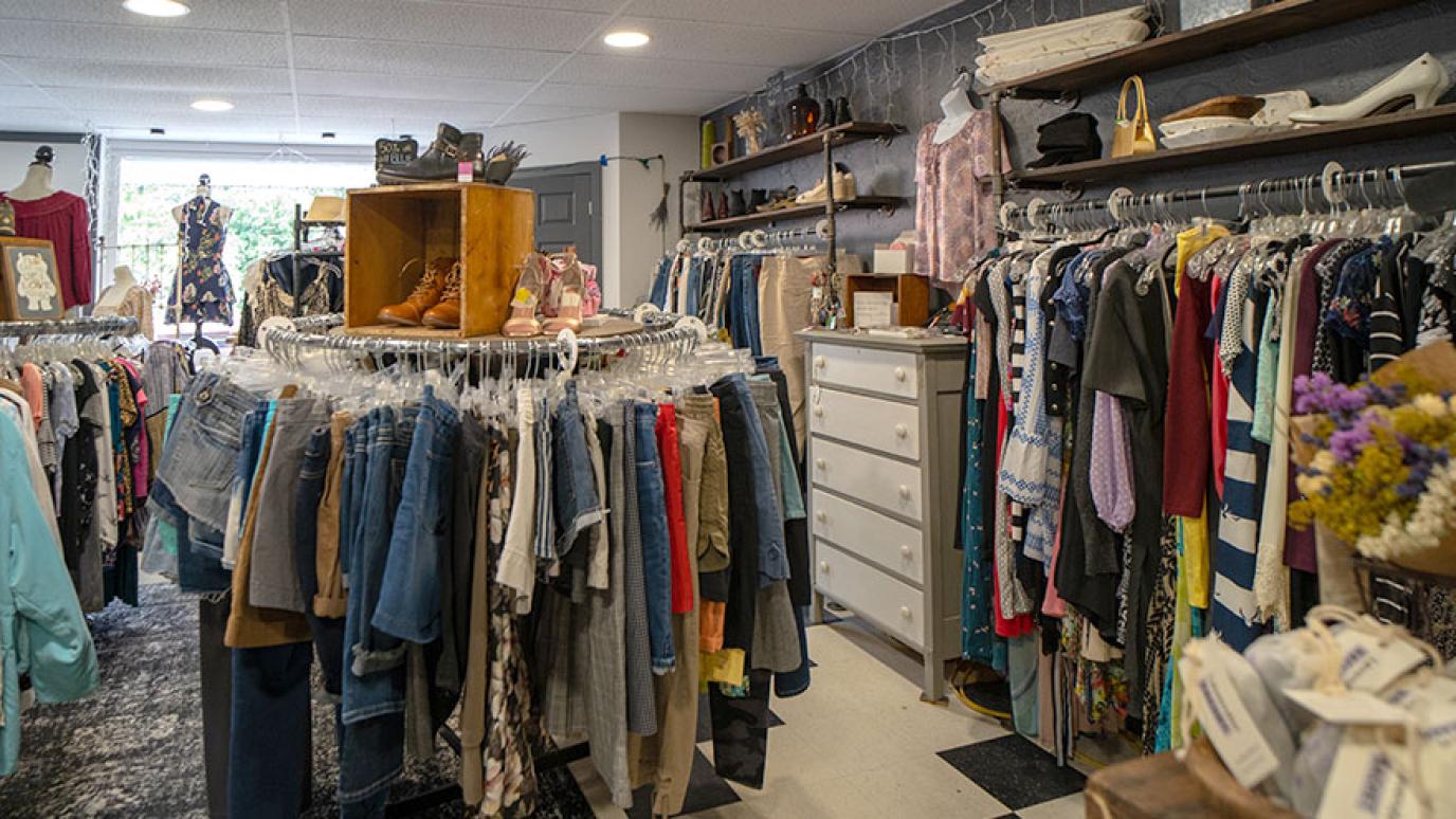 A second hand clothing shop with racks of vintage clothes and accessories