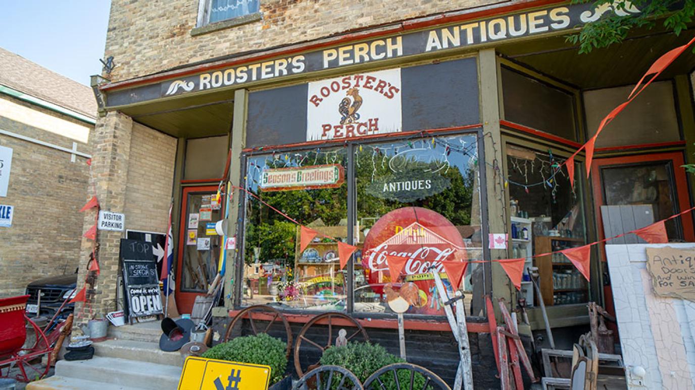 An antique storefront with lots of items displayed outside.