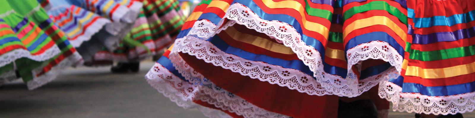 The bottom of brightly coloured skirts in motion during a dance