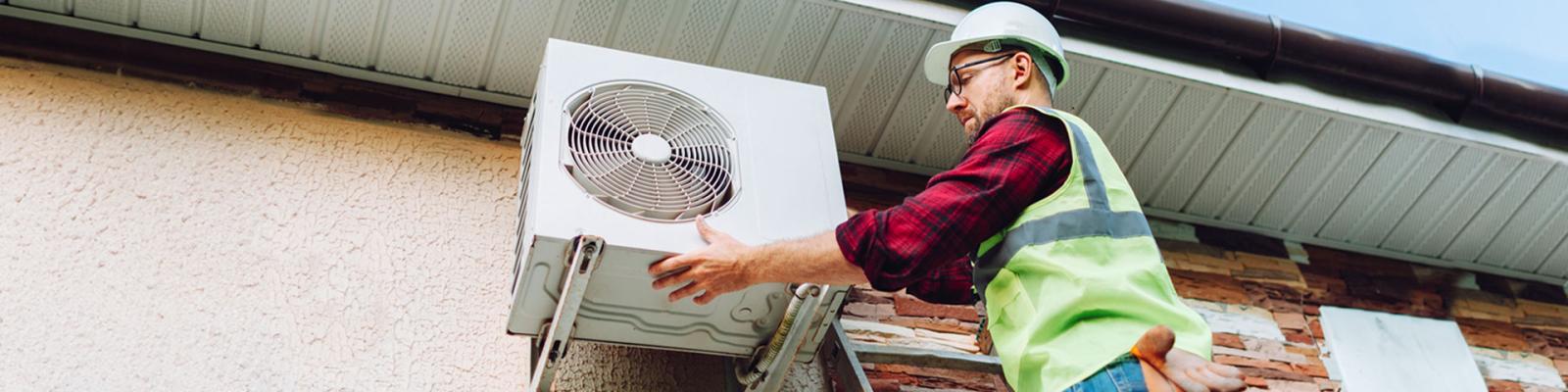 Technician in uniform repairing heat pump