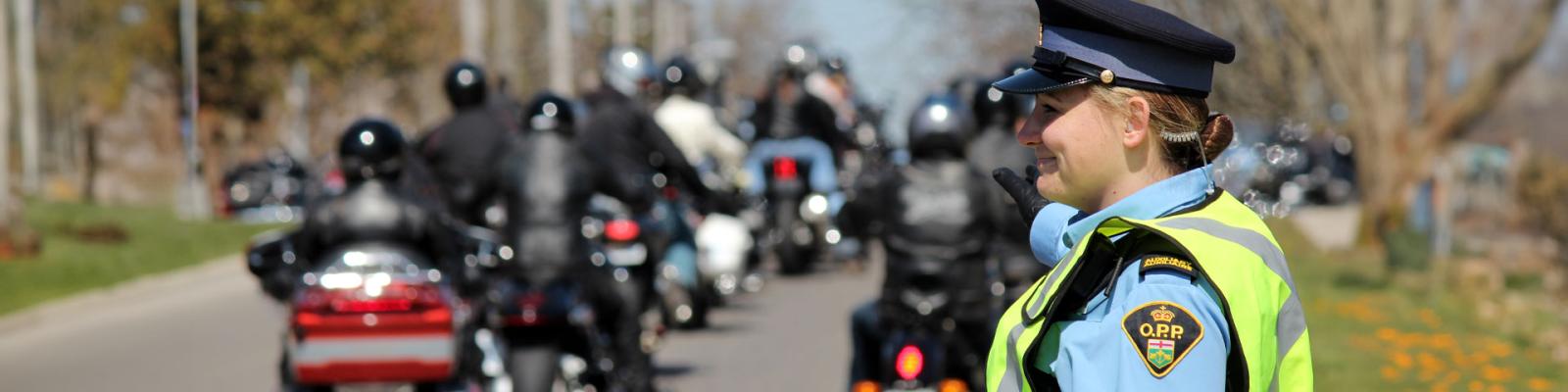 OPP officer directing traffic of motorcyclists on a clear summer road