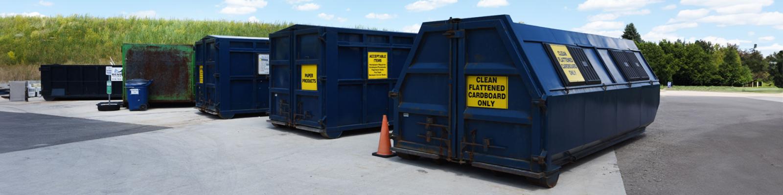 Large Bins labelled metal bins for garbage and recycling sorting at waste facility
