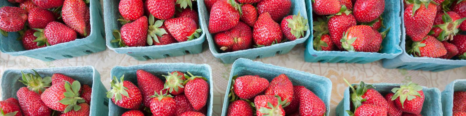 Baskets of strawberries at a market viewed from above