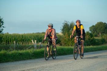 two people biking down country road