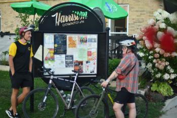 two people on bikes looking at information board downtown harriston