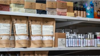 A close-up image of a variety of colourful handmade soaps on a white shelf. 