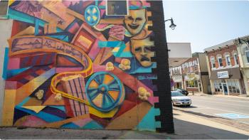 A large colourful wall mural showcases theatrical illustrations downtown Minto