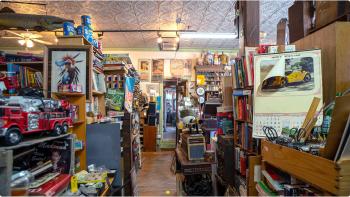 A narrow path through the cluttered shelves filled with vintage treasures in an antique shop.