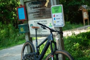 bike leaning against wooden bike trail sign