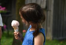 A girl enjoying an ice cream cone on a farm