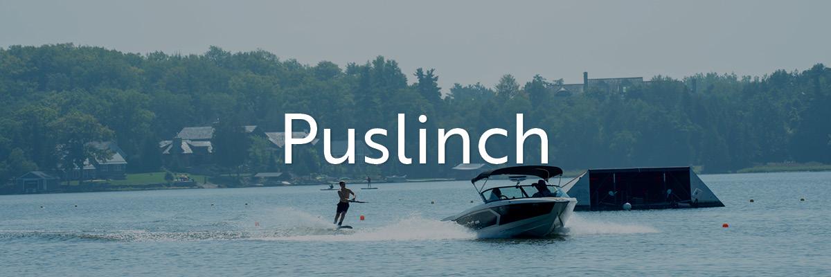 People boating, water skiing, and paddle boarding on Puslinch Lake.
