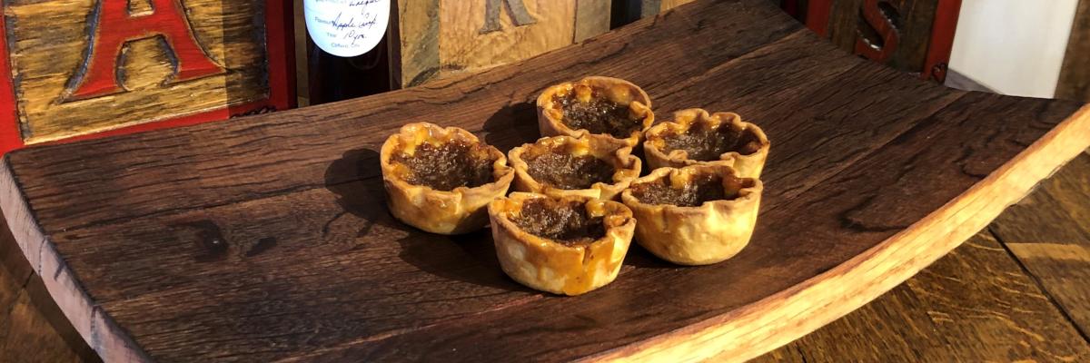 butter tarts on top of a board made from a barrel