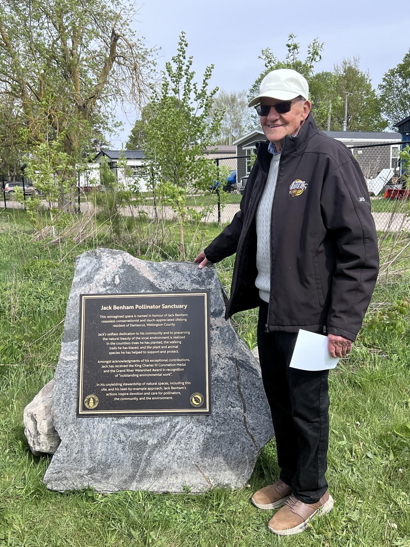Jack Benham standing by his dedication plaque. 